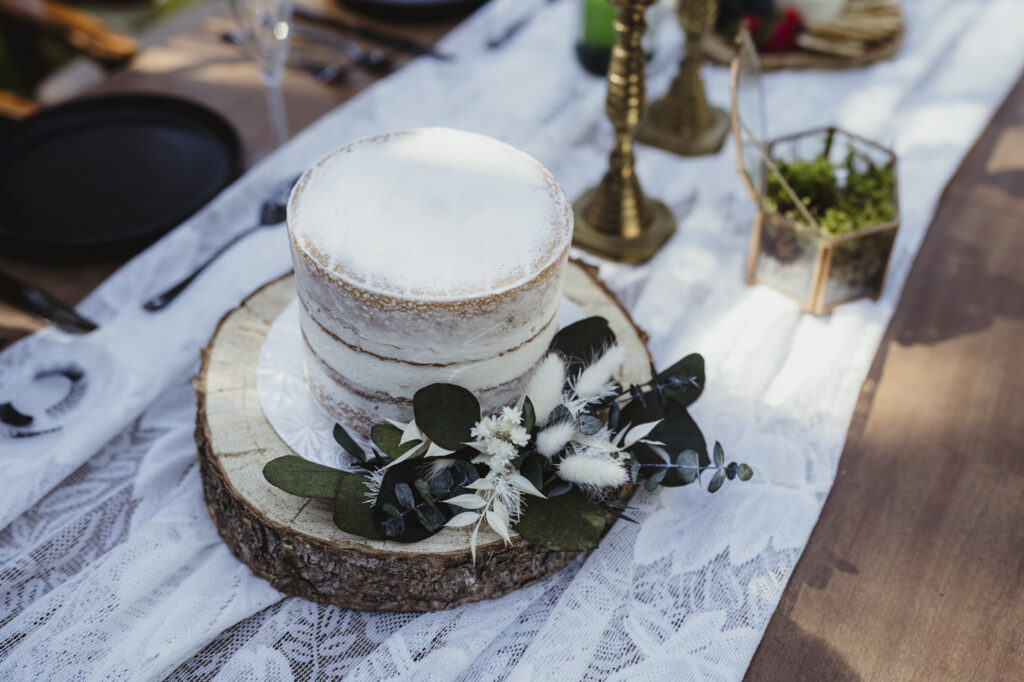 Boho, nude lemon wedding cake with embellishments on a carved piece of pine. 