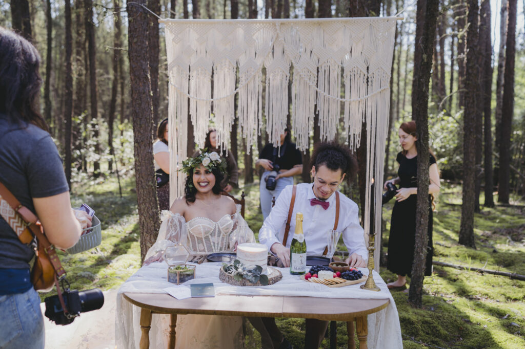 A boho bride and groom getting married in the forest during a photographer workshop. 