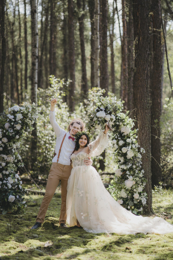 A boho bride and groom celebrating just getting married in the forest.