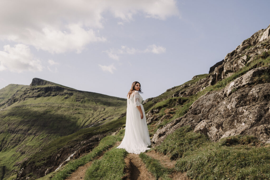 Bride posing in the middle of the beautiful landscape on a Faroe Islands. 