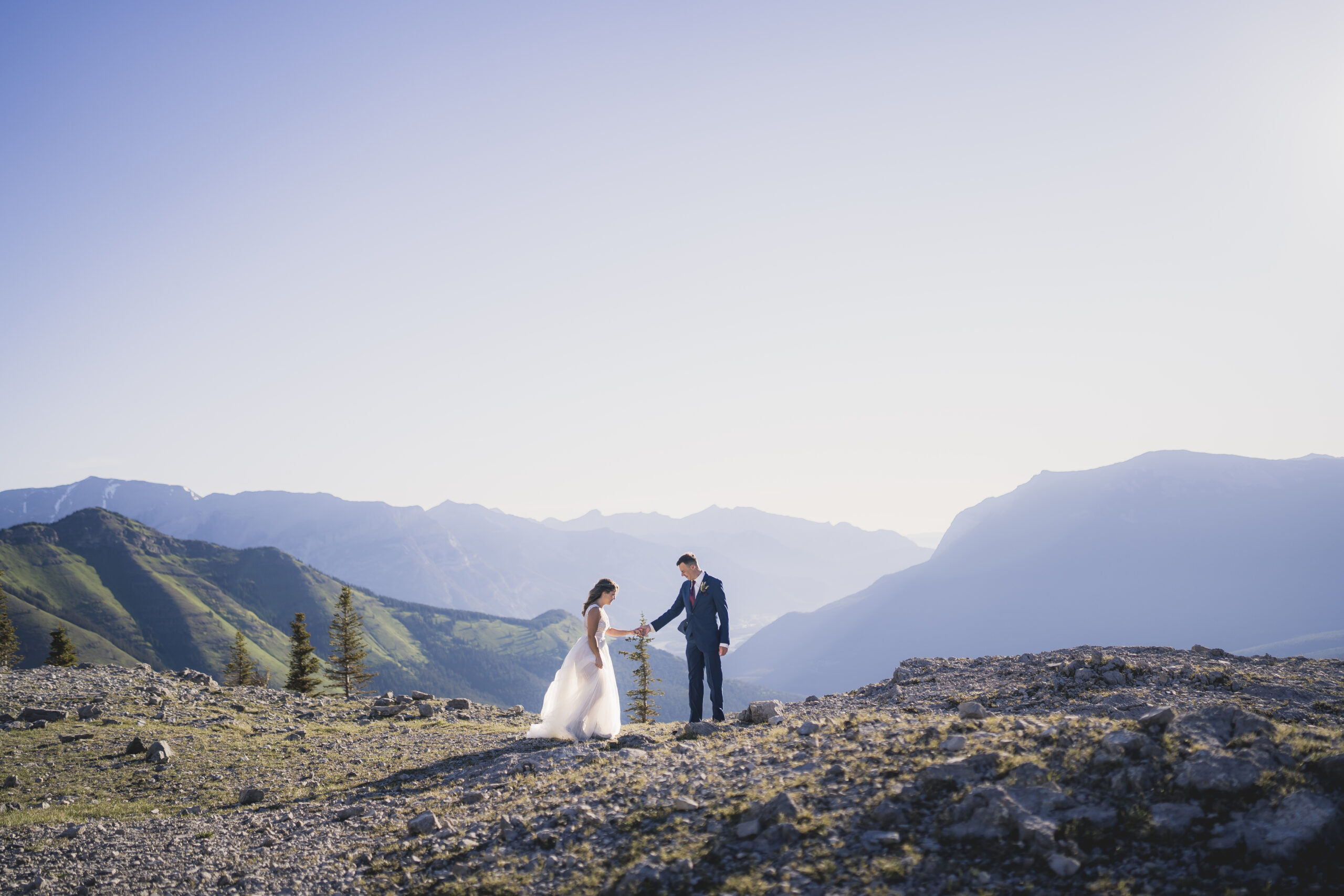 Bride and Groom walking up to each other at the top of a mountain during their Canmore elopement.