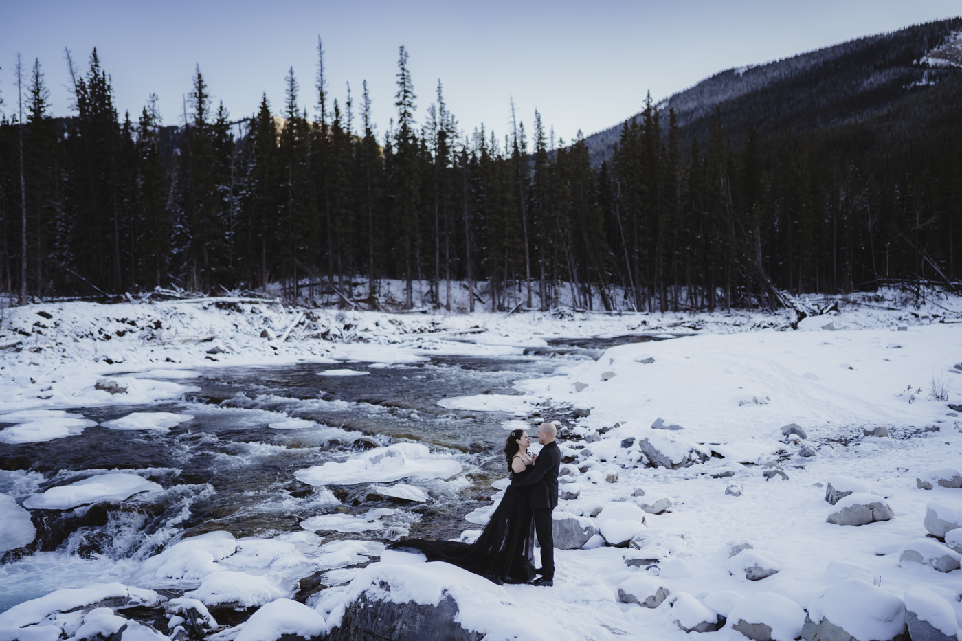 Canmore Elopement at Elbow Falls, with frozen river in the background.