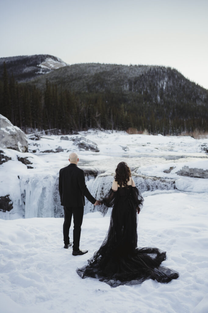 Canmore Elopement at Elbow Falls, with frozen river in the background.