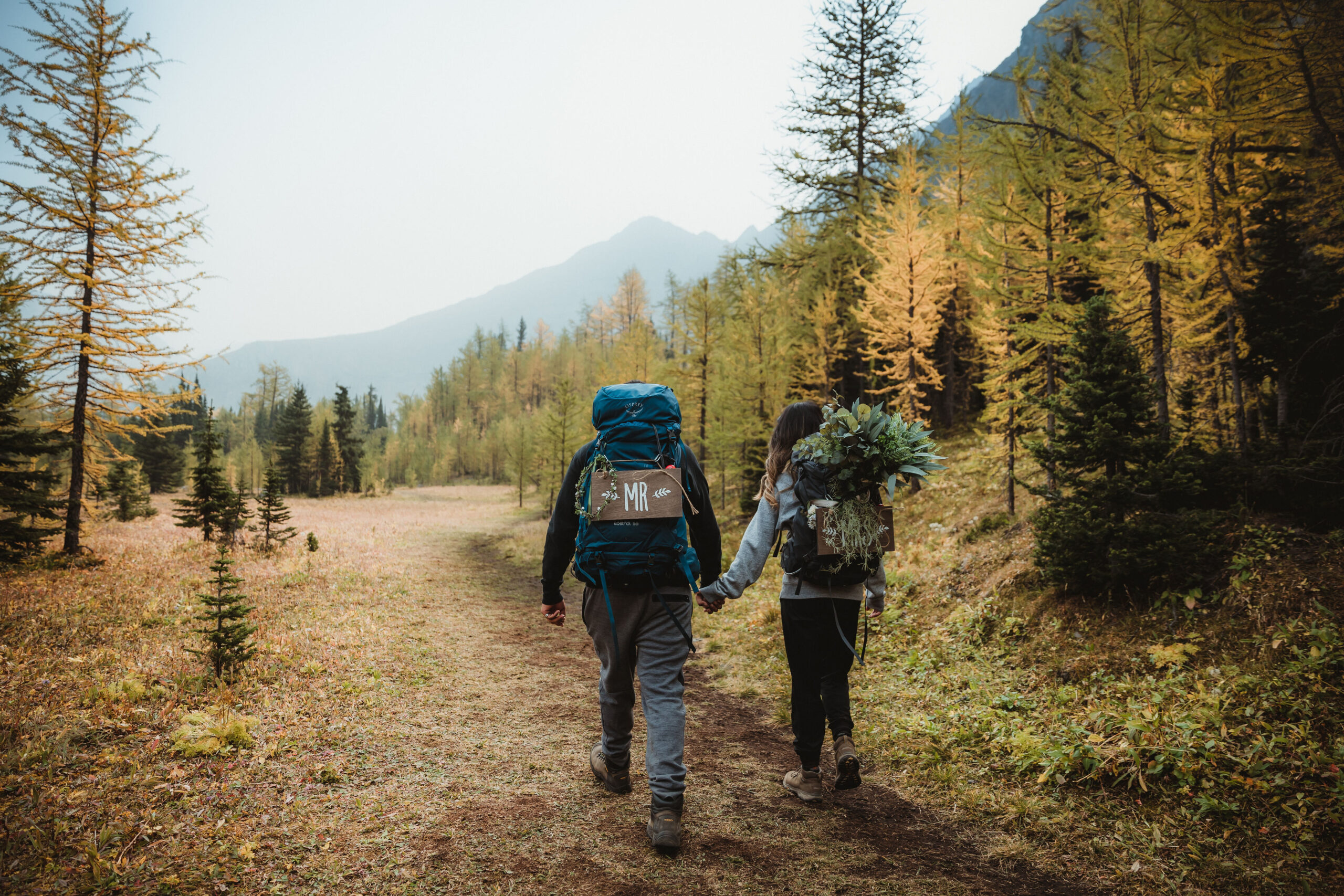 Couple hiking back from their sunrise elopement with their canmore elopement photographer.