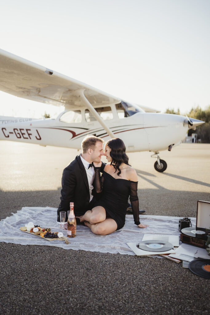 Couple in front of an airplane at Edmonton flight club during their engagement session. 